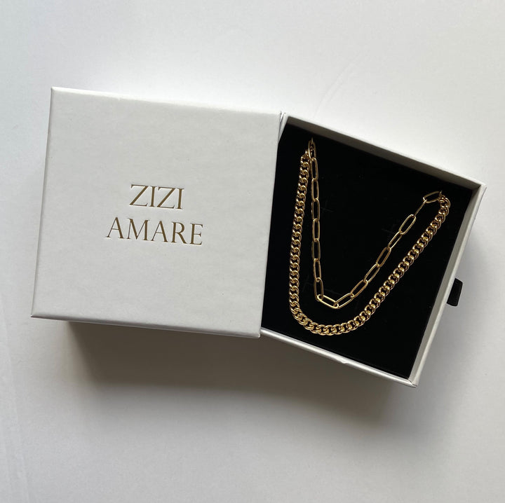 a gold curb chain and gold paperclip chain packed in a jewelry box with the ZiZi Amare logo