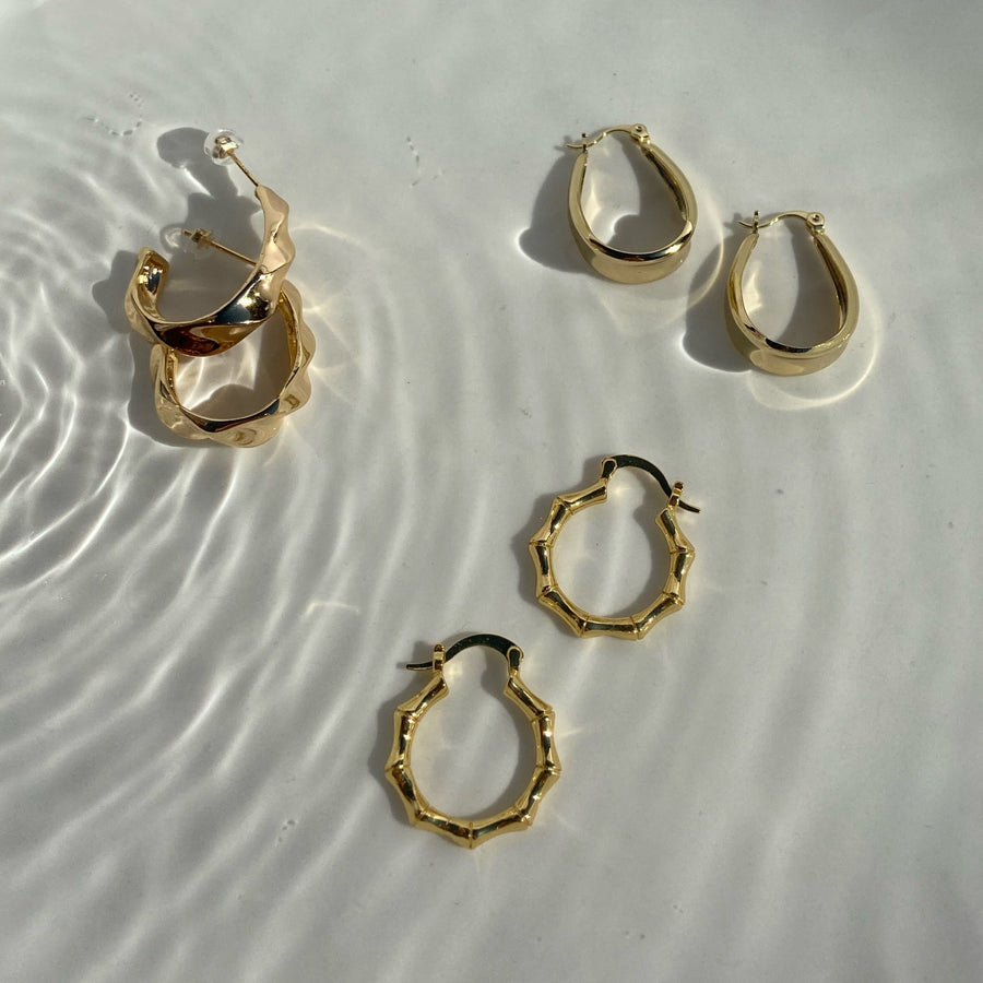 gold hoop earrings on a plate of water
